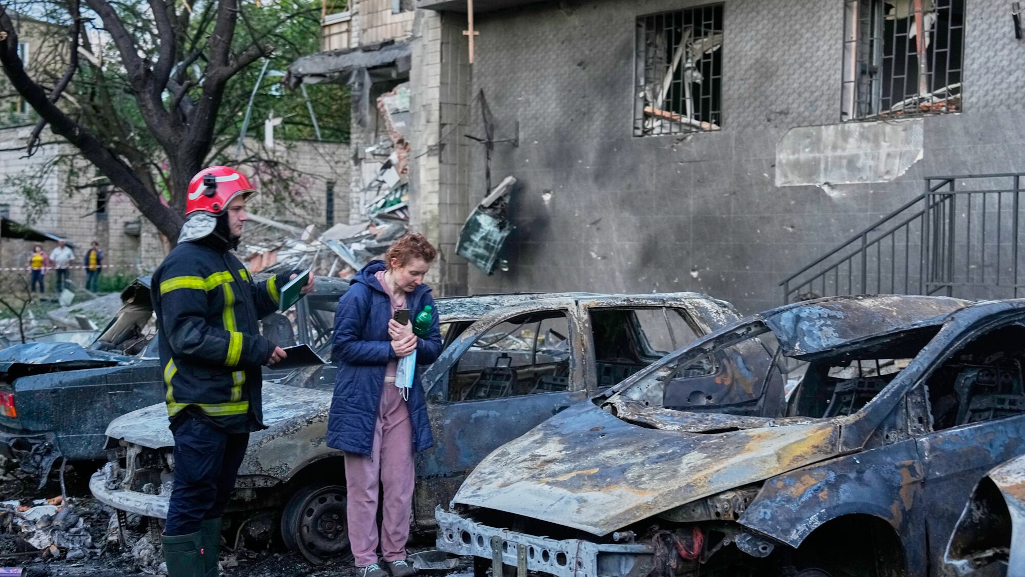 Власниця оглядає пошкоджений вибухом автомобіль