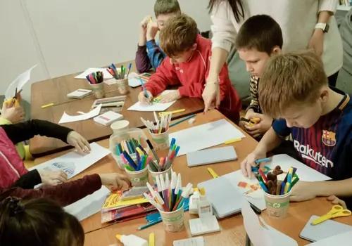 Children doing art therapy at a table at a Save Ukraine reception center