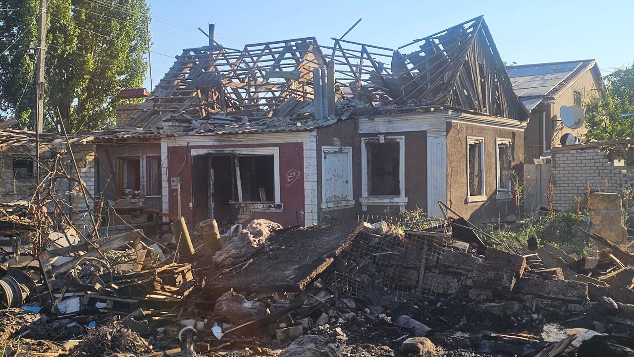 Another house with its roof torn off and rafters exposed in the same Kherson neighborhood