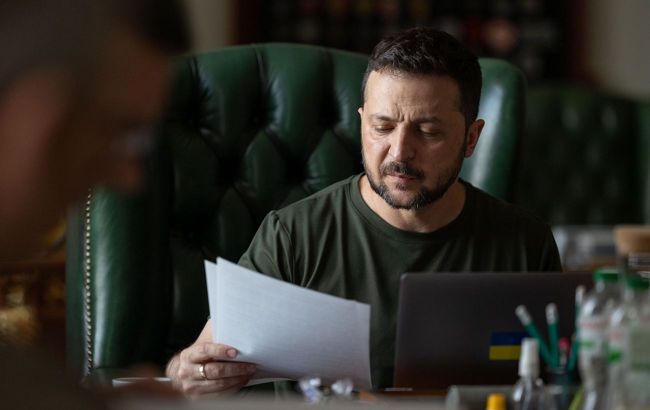 Президент Зеленський переглядає підписані документи (ілюстративне фото з офіційної сторінки Президента України)