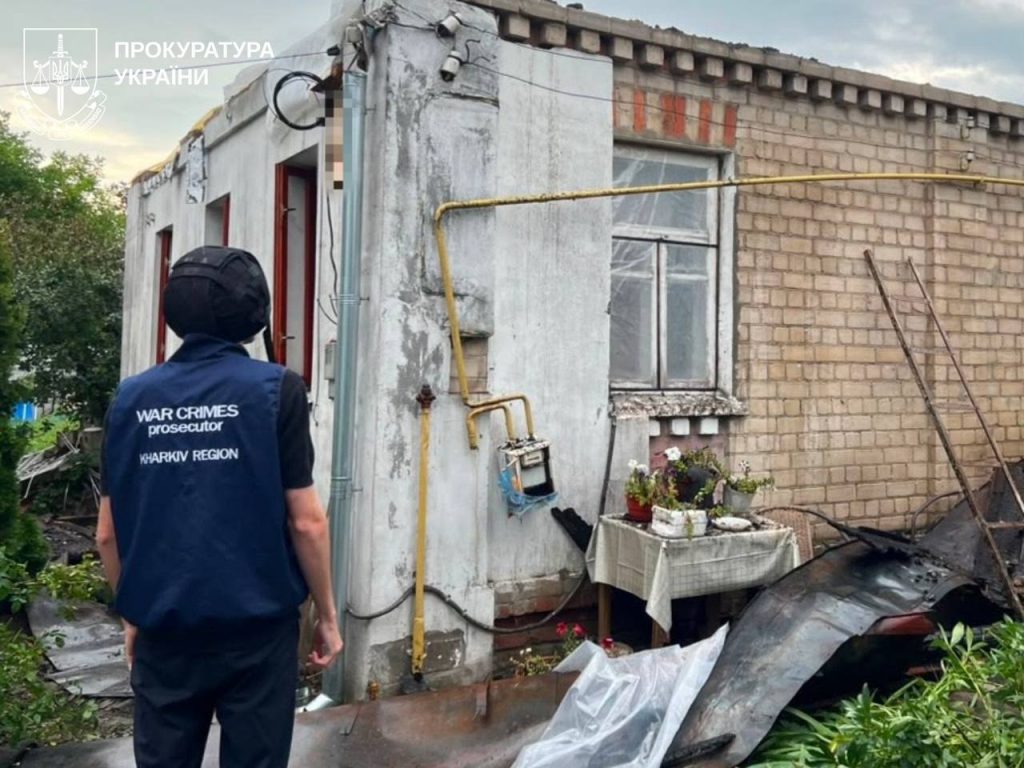 Працівники прокуратури оглядають вигорілий житловий будинок у Харкові вдень