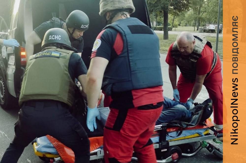 Медична бригада завантажує пораненого на ноші в карету швидкої допомоги