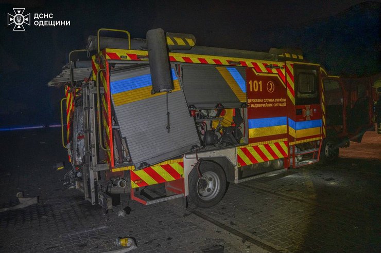 Пожежник на місці удару в порту Одеси на тлі пошкоджених контейнерів