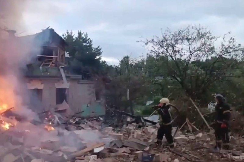Пожежники гасять охоплену вогнем частково зруйновану будівлю в присмерку в Істринському районі