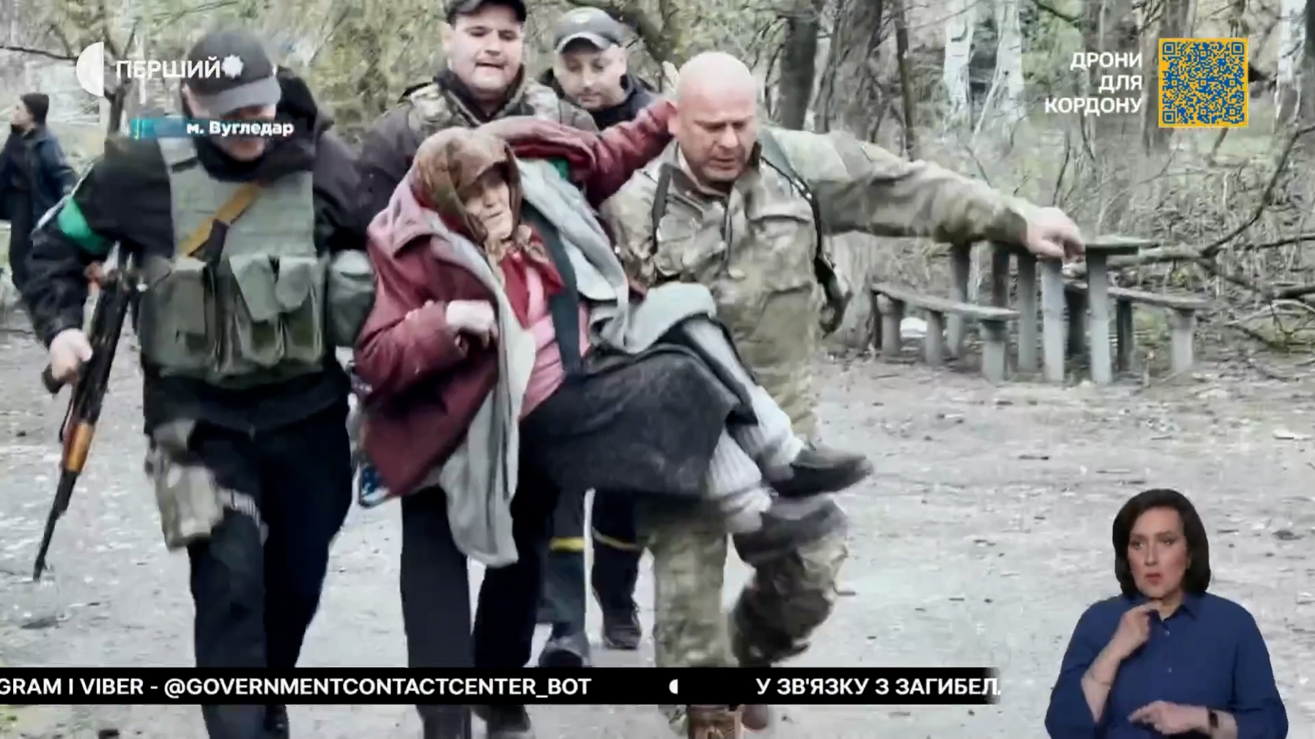 Бійці підрозділу виносять на руках літню жінку з небезпечної зони під час евакуації