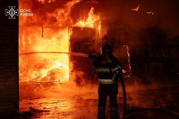 Рятувальник ДСНС гасить пожежу на місці удару в Києві