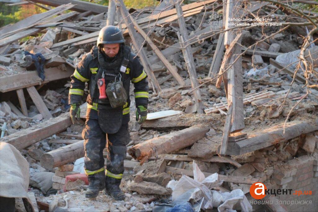 A rescuer searches through the rubble of the destroyed house