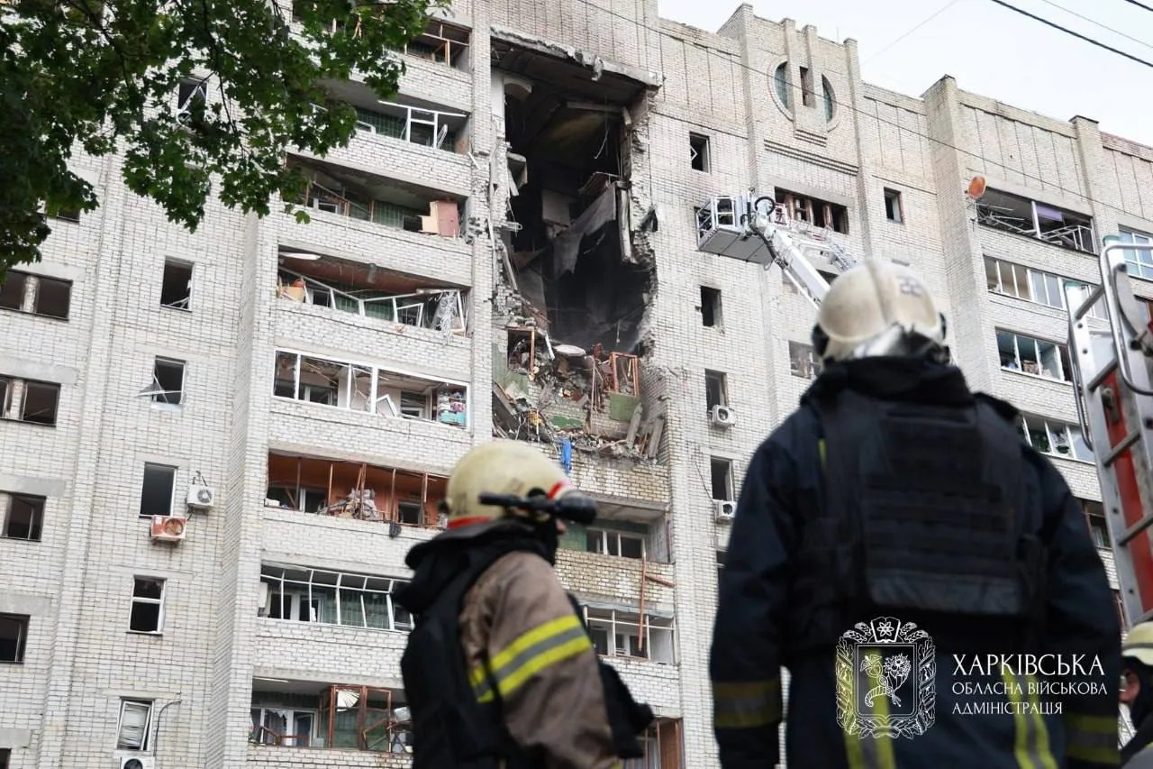 Пожежники оглядають пошкоджений під'їзд багатоповерхівки в Харкові після удару