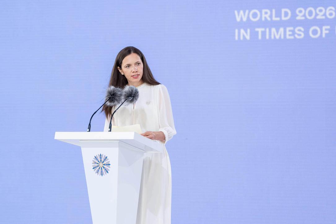Перша леді Румунії Мірабела Ґредіняну виступає з трибуни саміту на тлі напису «Світ-2026: віднайти опору в часи невизначеності»