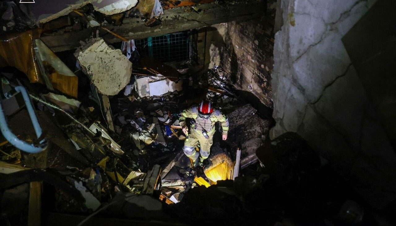 A rescuer amid the rubble of a Kyiv building destroyed by a direct hit