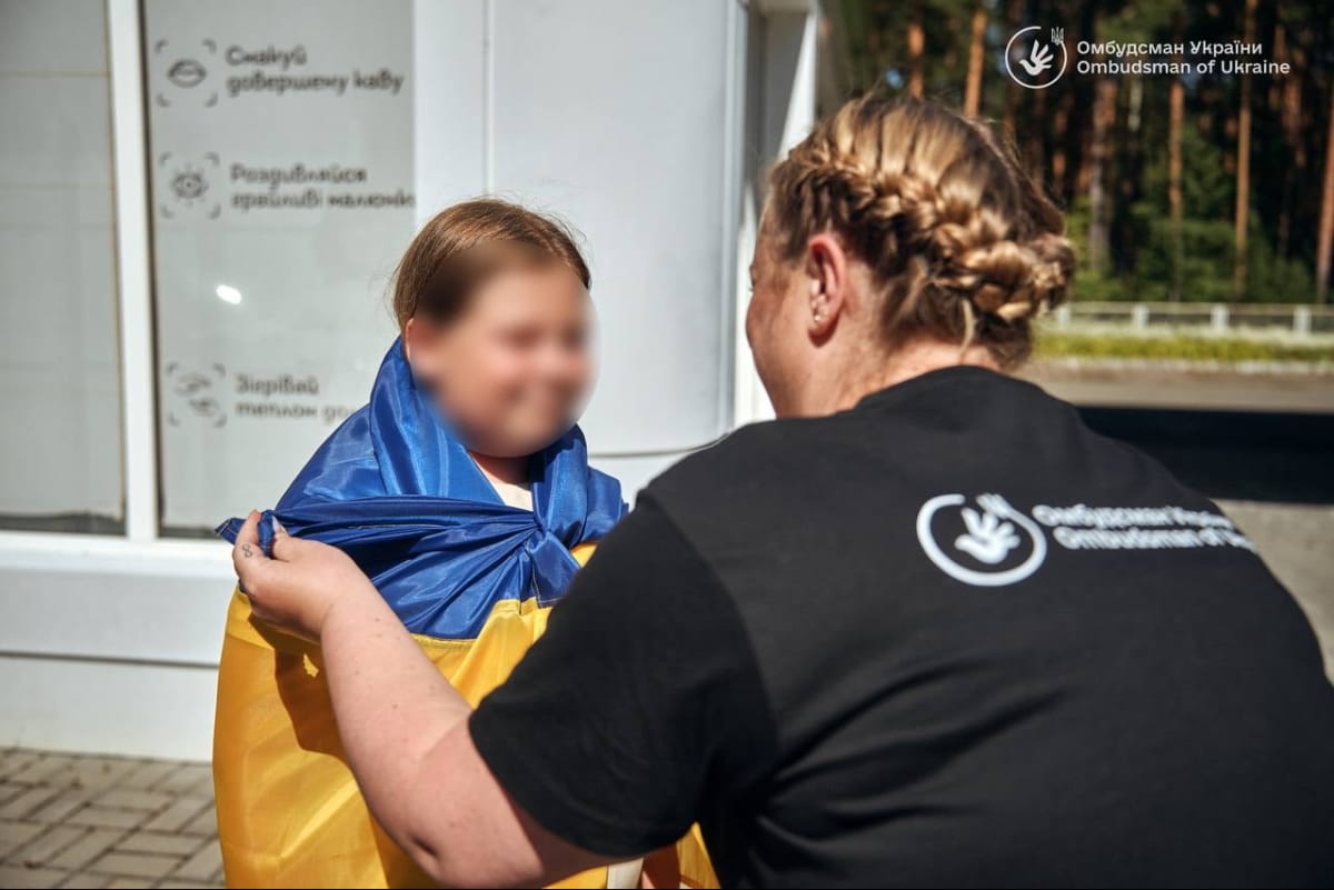 Дитину, повернуту з окупації, огортають прапором України