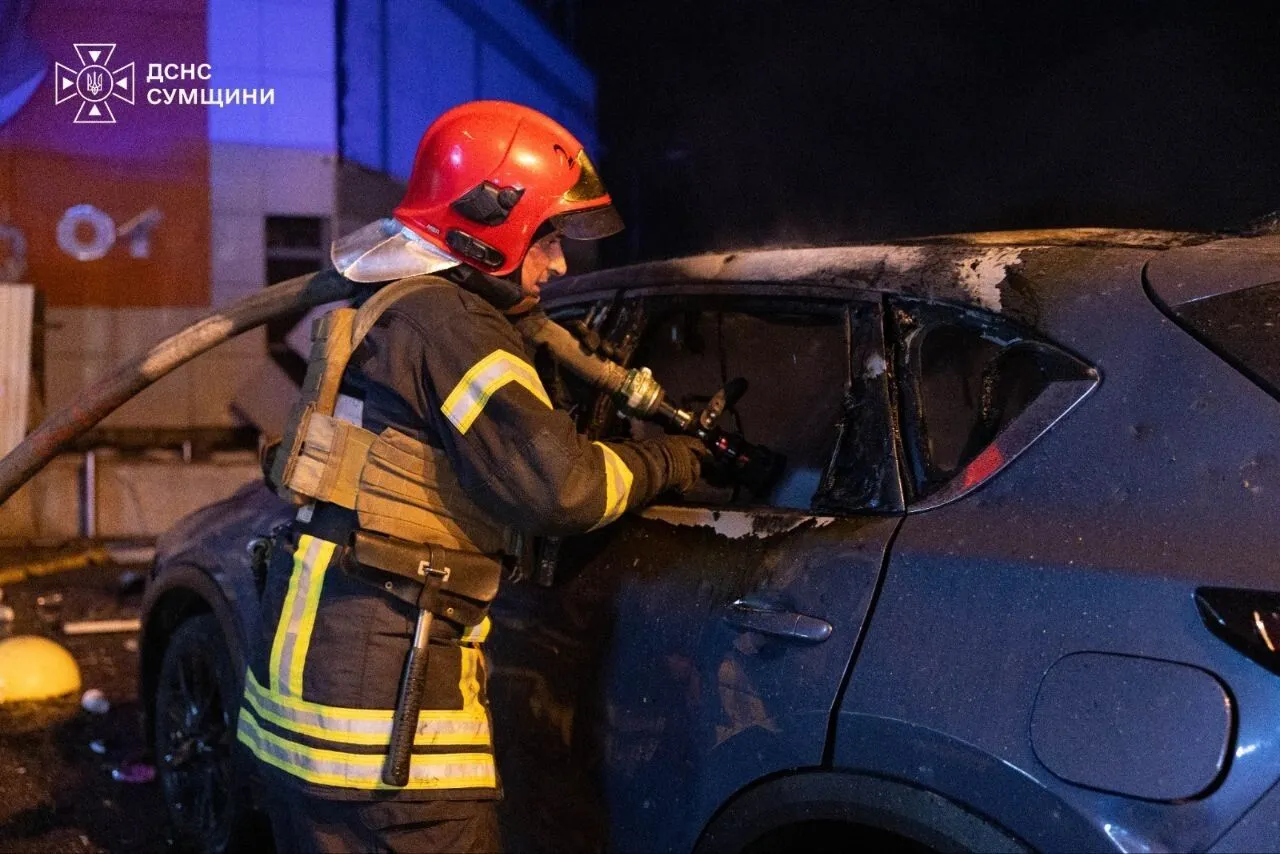 Рятувальник ДСНС Сумщини гасить вогонь у салоні згорілого автомобіля біля ТРЦ «Мануфактура»