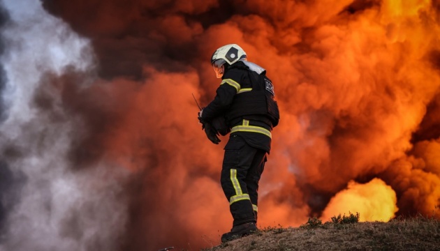 A Ukrainian State Emergency Service firefighter battles a large blaze at the scene of a strike