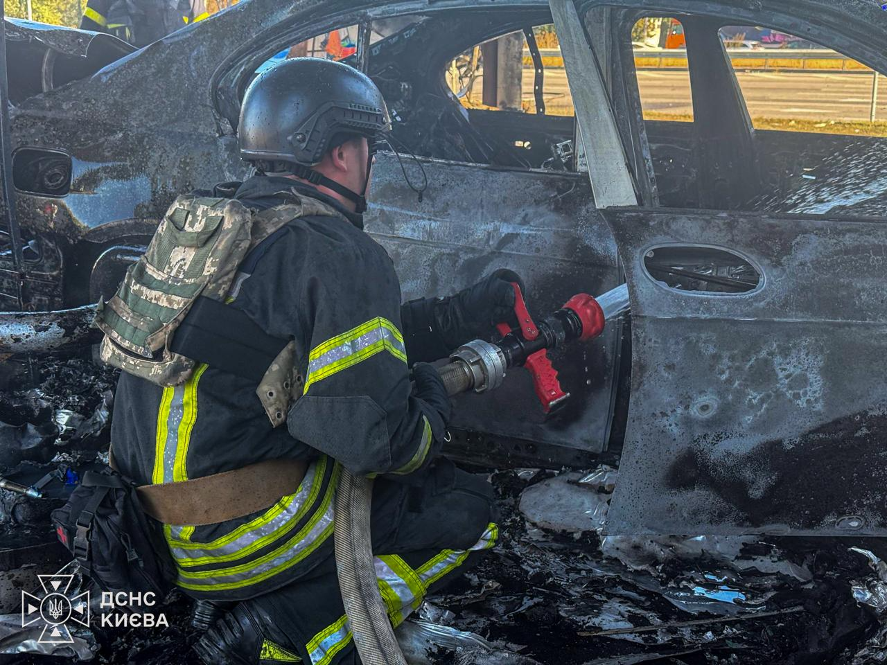 Рятувальник гасить рештки автомобіля, який згорів на території заправки