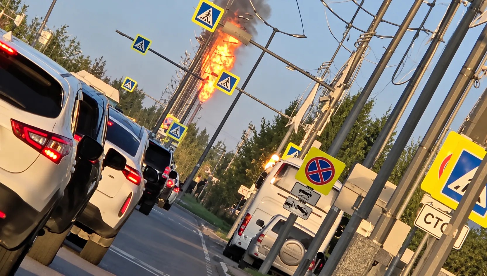 Кадр із вулиці міста: над дахами будинків видно потужну пожежу на газопереробному підприємстві
