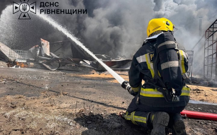 A firefighter works to extinguish a large fire at a damaged industrial enterprise in Sarny district