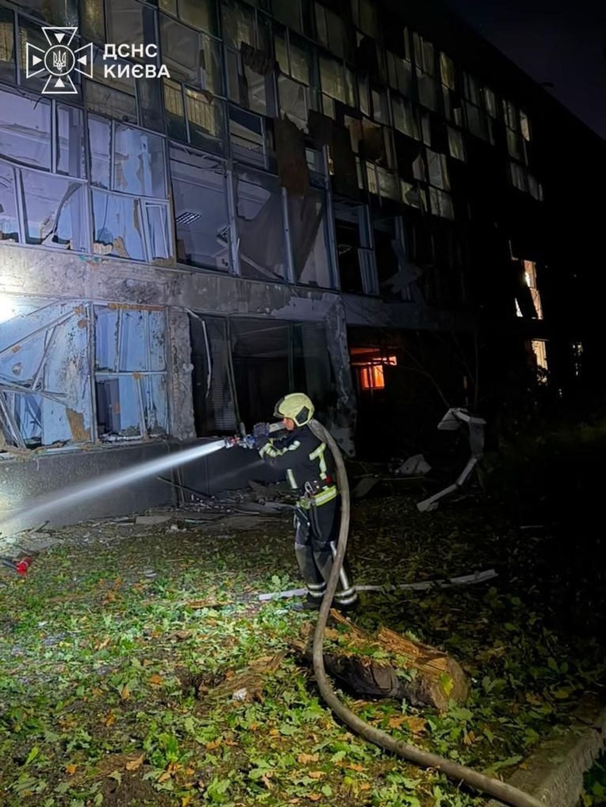 A firefighter tackles the aftermath of a fire at a damaged education facility in Kyiv