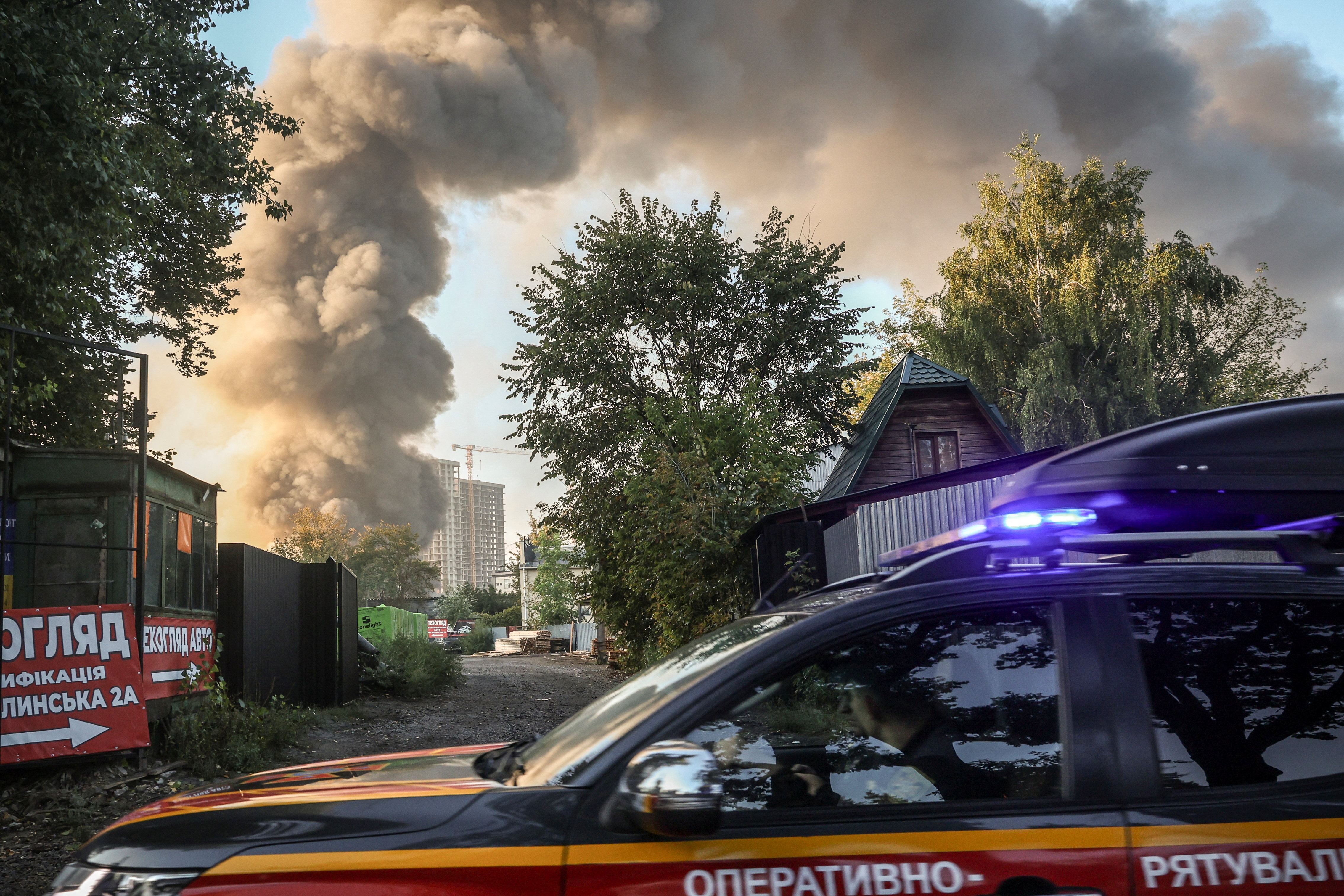 Emergency vehicles and smoke over a district of Kyiv after the overnight attack