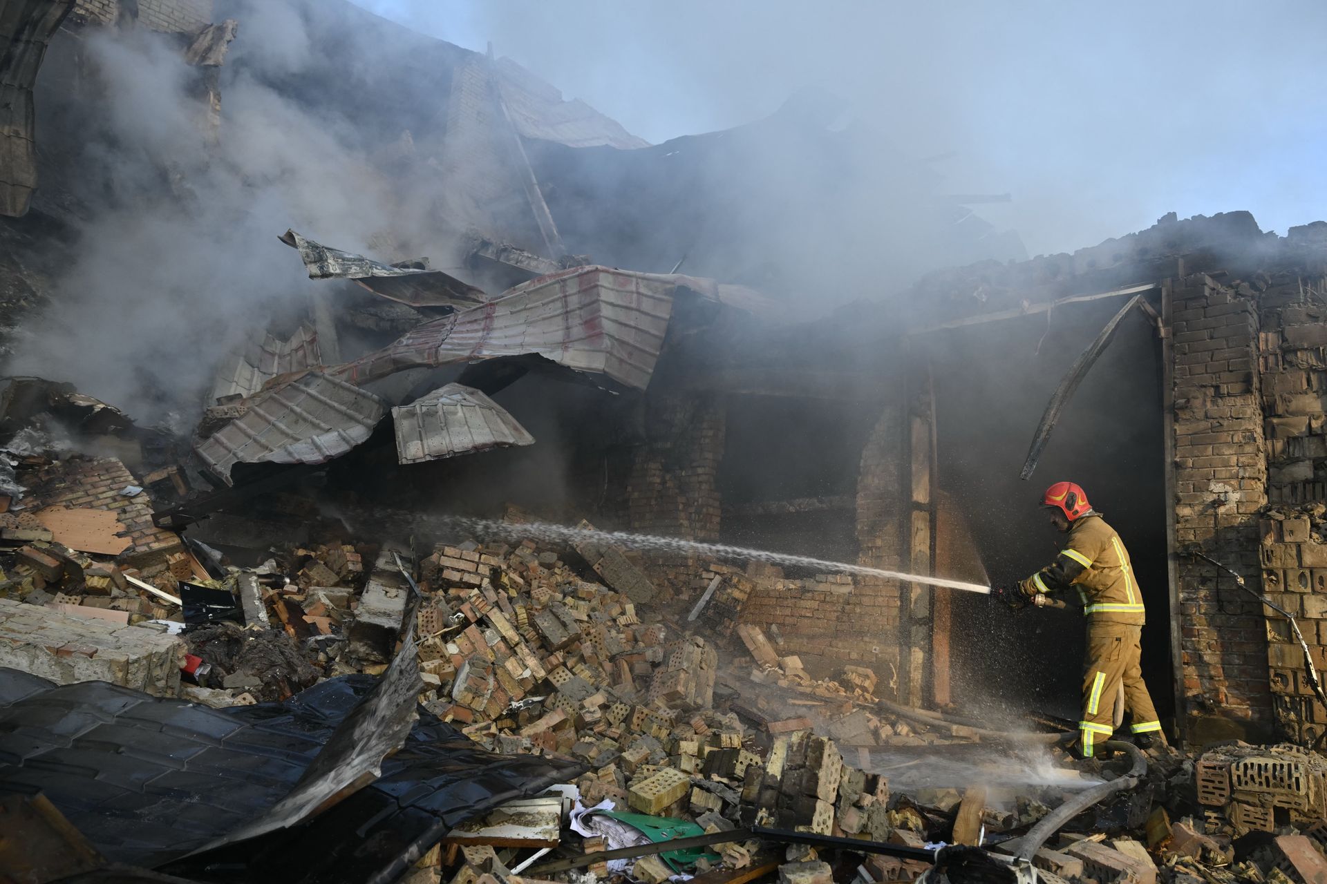 Рятувальники гасять пожежу у зруйнованій будівлі в Києві після ракетно-дронового удару 8 вересня
