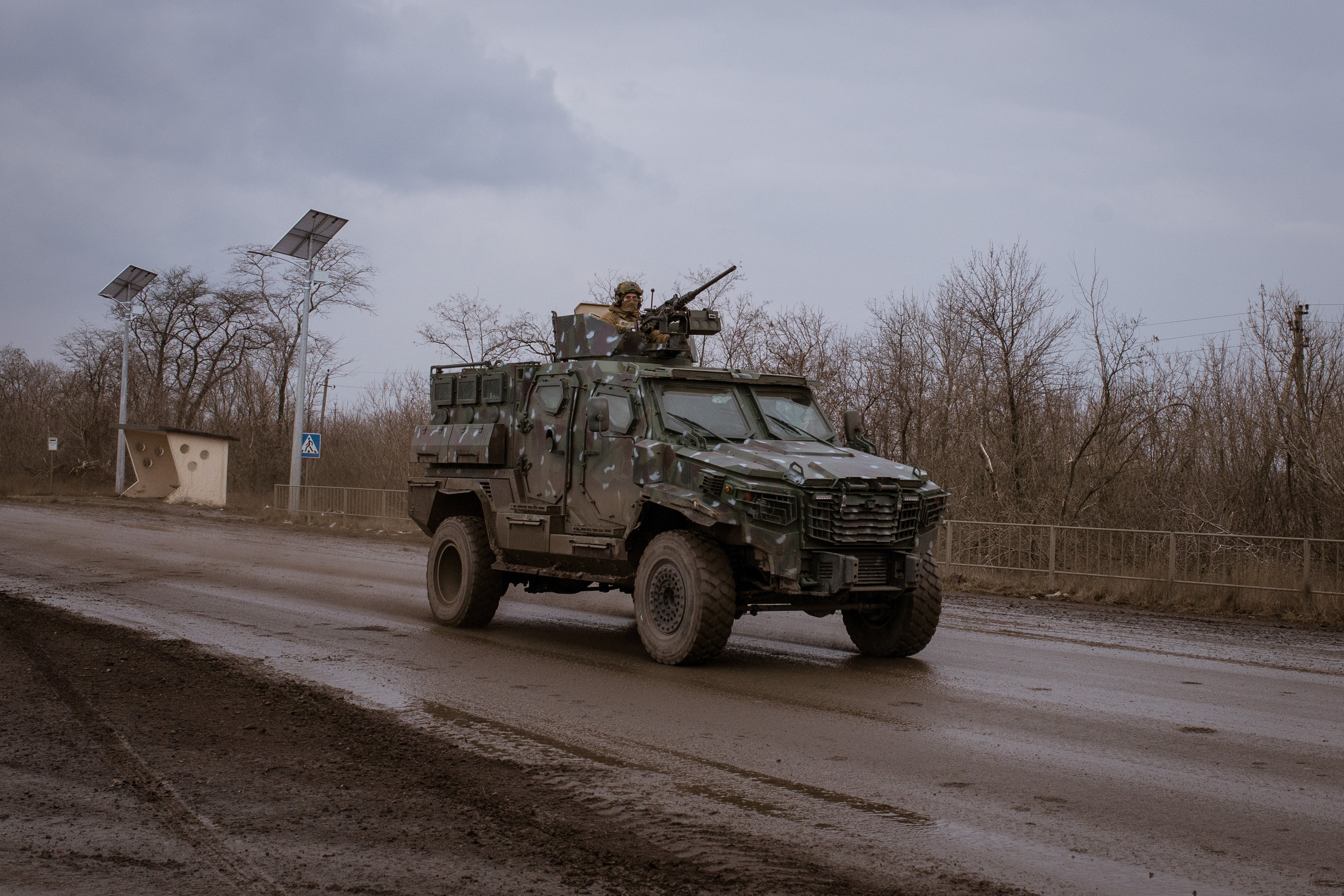 Illustrative photo: a Ukrainian serviceman patrols past destroyed buildings, Donetsk Oblast