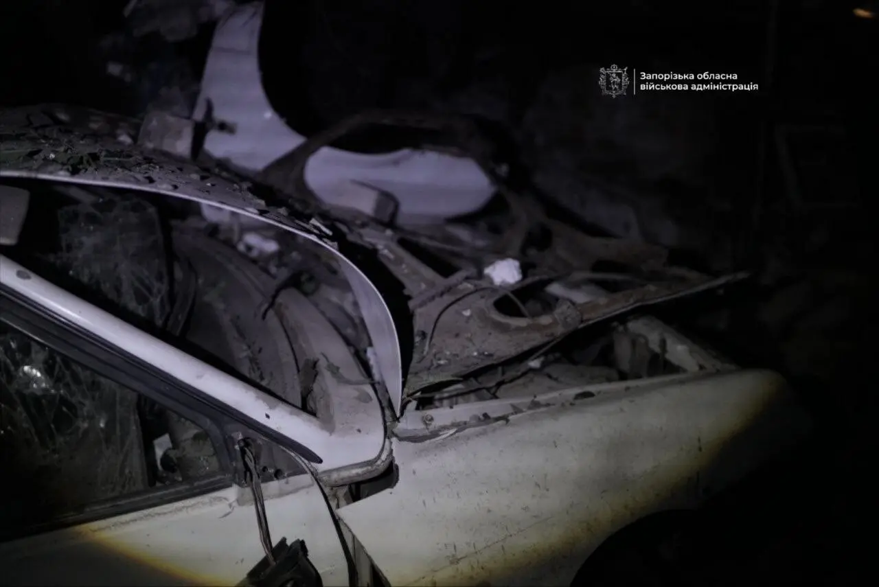 Понівечений вибухом автомобіль біля зруйнованого будинку
