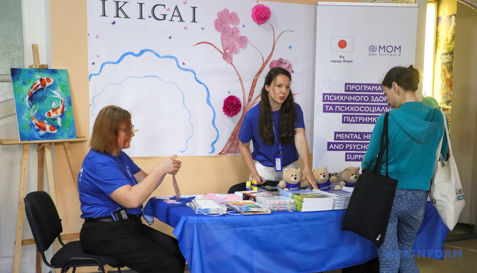 Волонтерки проводять майстер-клас на тлі малюнка «Ікігай» під час фестивалю «Японська осінь», Київ