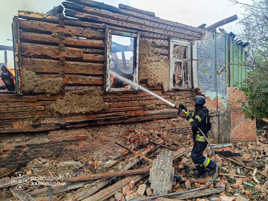A firefighter extinguishes a house destroyed in a strike on Izyum