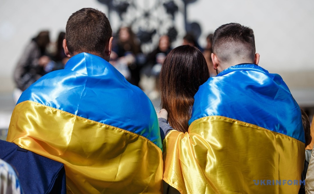 Ілюстративне фото: українці, які повернулися з окупації, загорнуті в прапор України