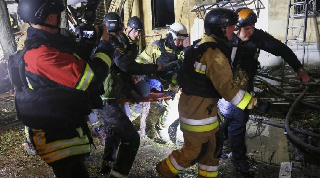 Rescuers carrying an injured person out of the rubble in Kharkiv