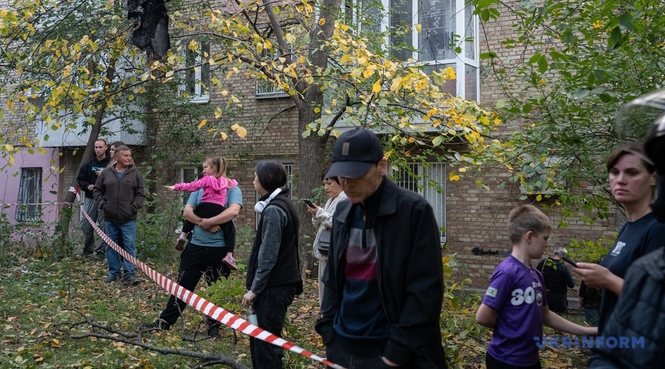 Residents by a cordoned-off courtyard after the attack