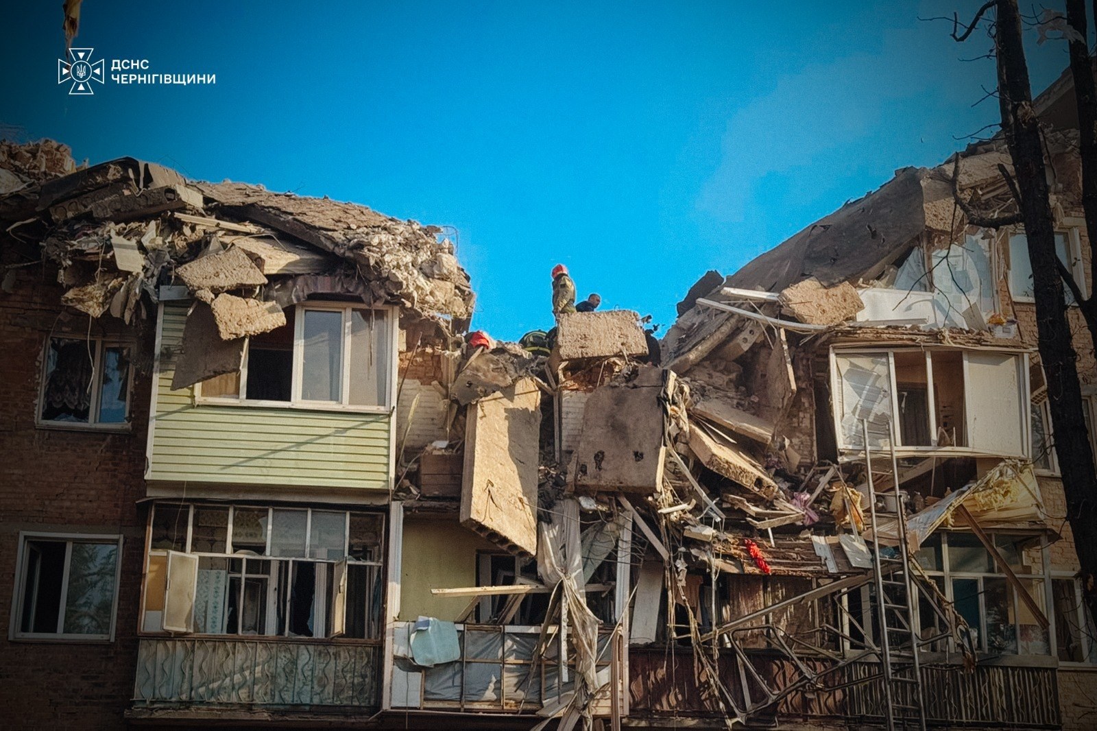 Rescuers and police officers clearing the rubble of the destroyed building in Pryluky