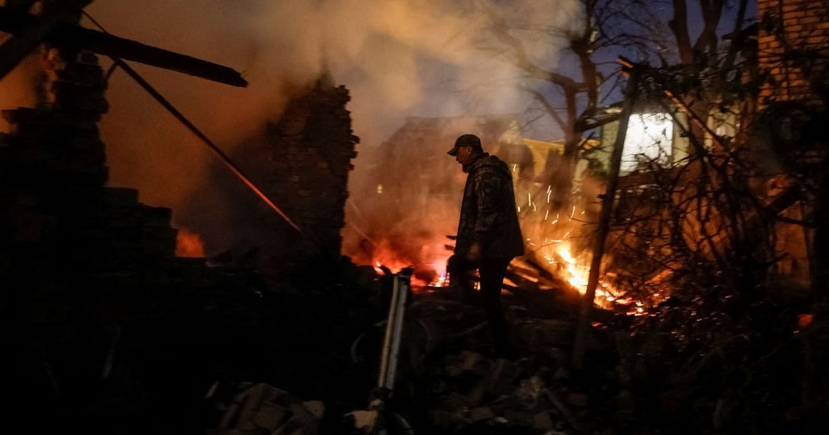 A man stands by the burning ruins of a private house in Kyiv at night. Photo: Reuters / TimesLive