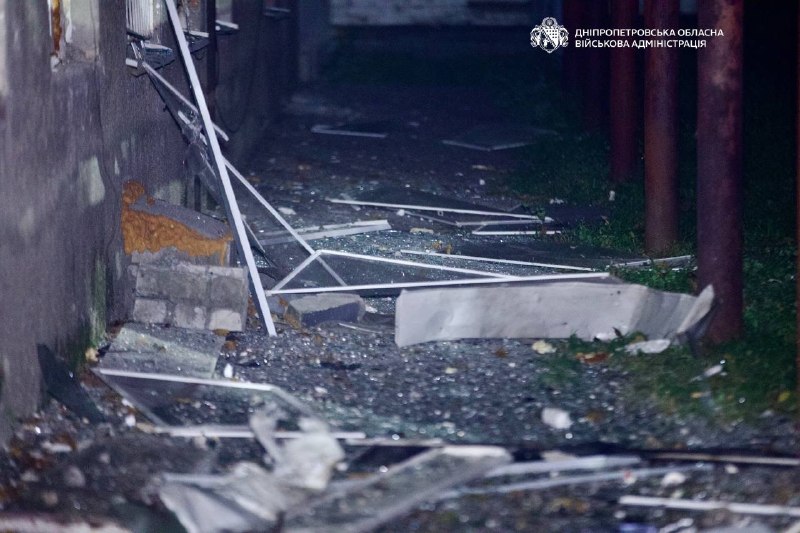 Broken glass and debris on the ground near the building after the hit