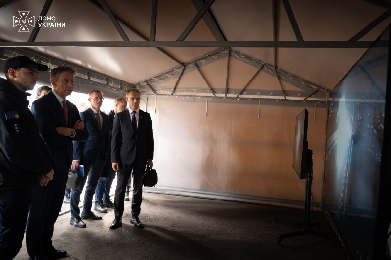 Delegation members and rescuers inside a DSNS mobile command post