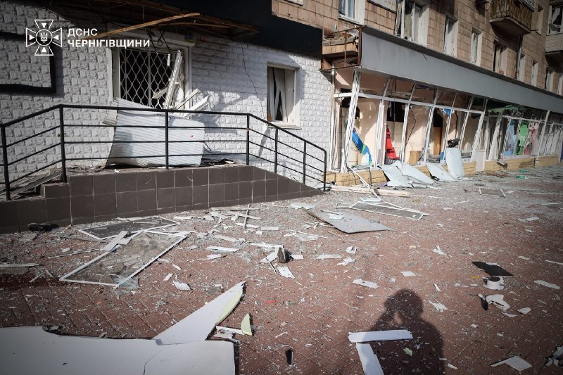 Smashed shop windows and broken glass by the entrances to the shops