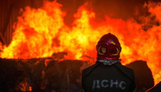 Illustrative photo: a State Emergency Service rescuer in front of flames