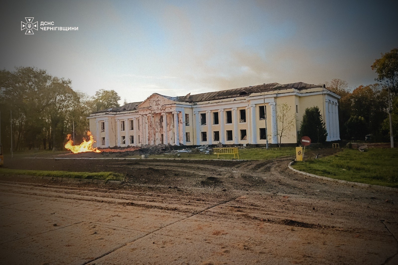 A damaged building in Pryluky after the attack, with fire visible on the grounds