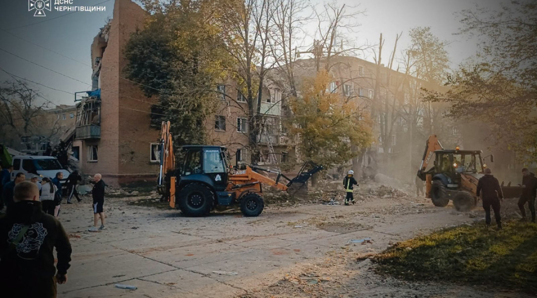 Heavy machinery clears the area near the destroyed buildings