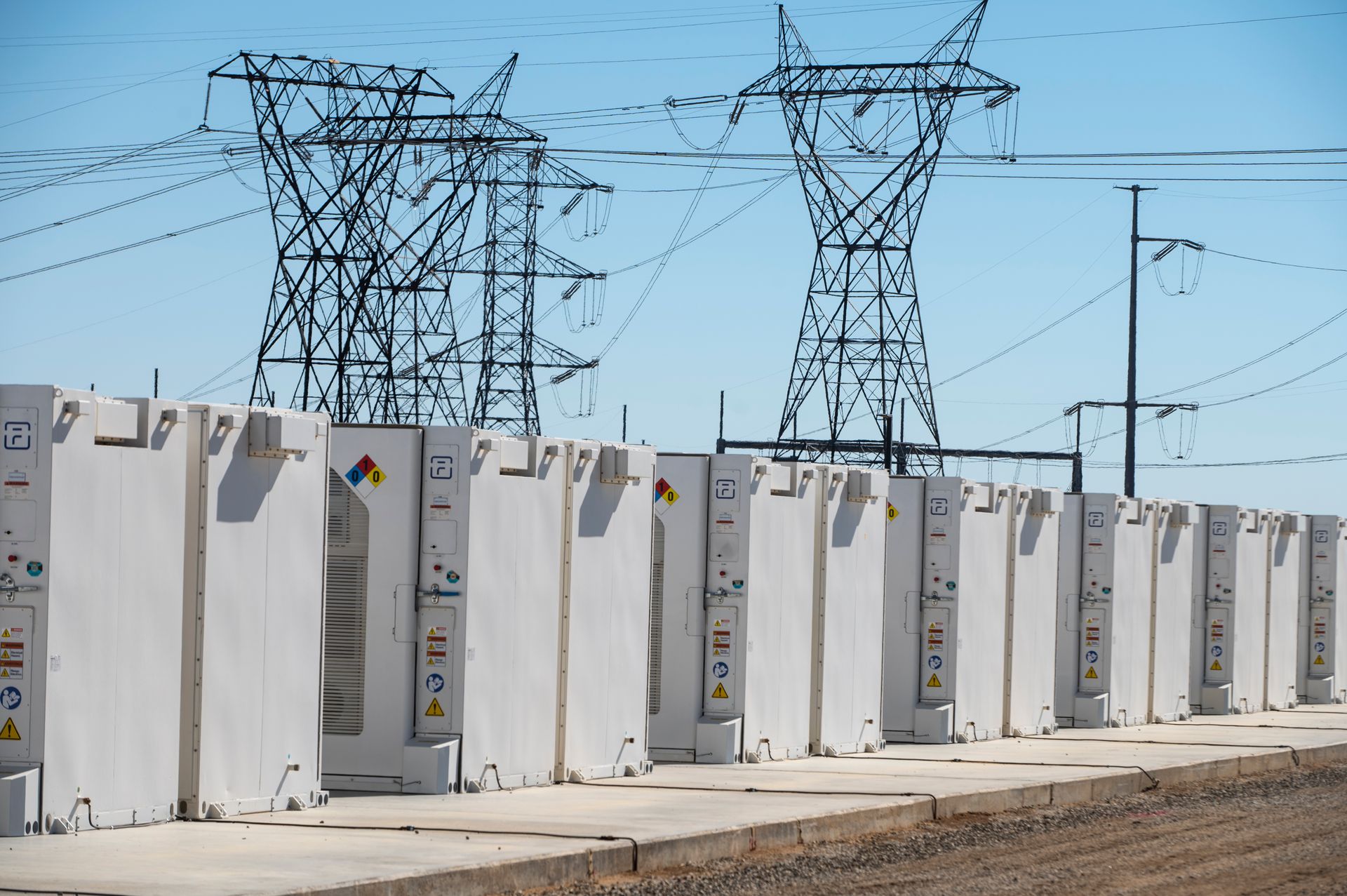 Illustrative photo: a battery storage array beside power lines
