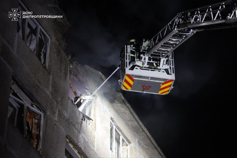 A rescue ladder beside the five-storey dormitory at night